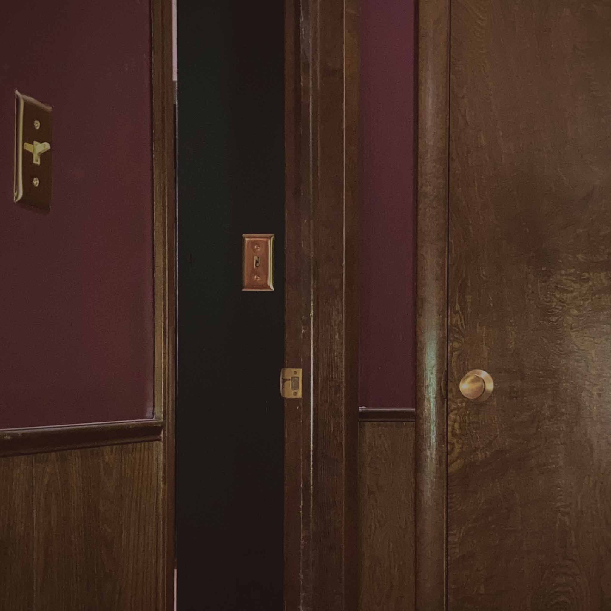 Doorway with burgundy walls and wood paneling