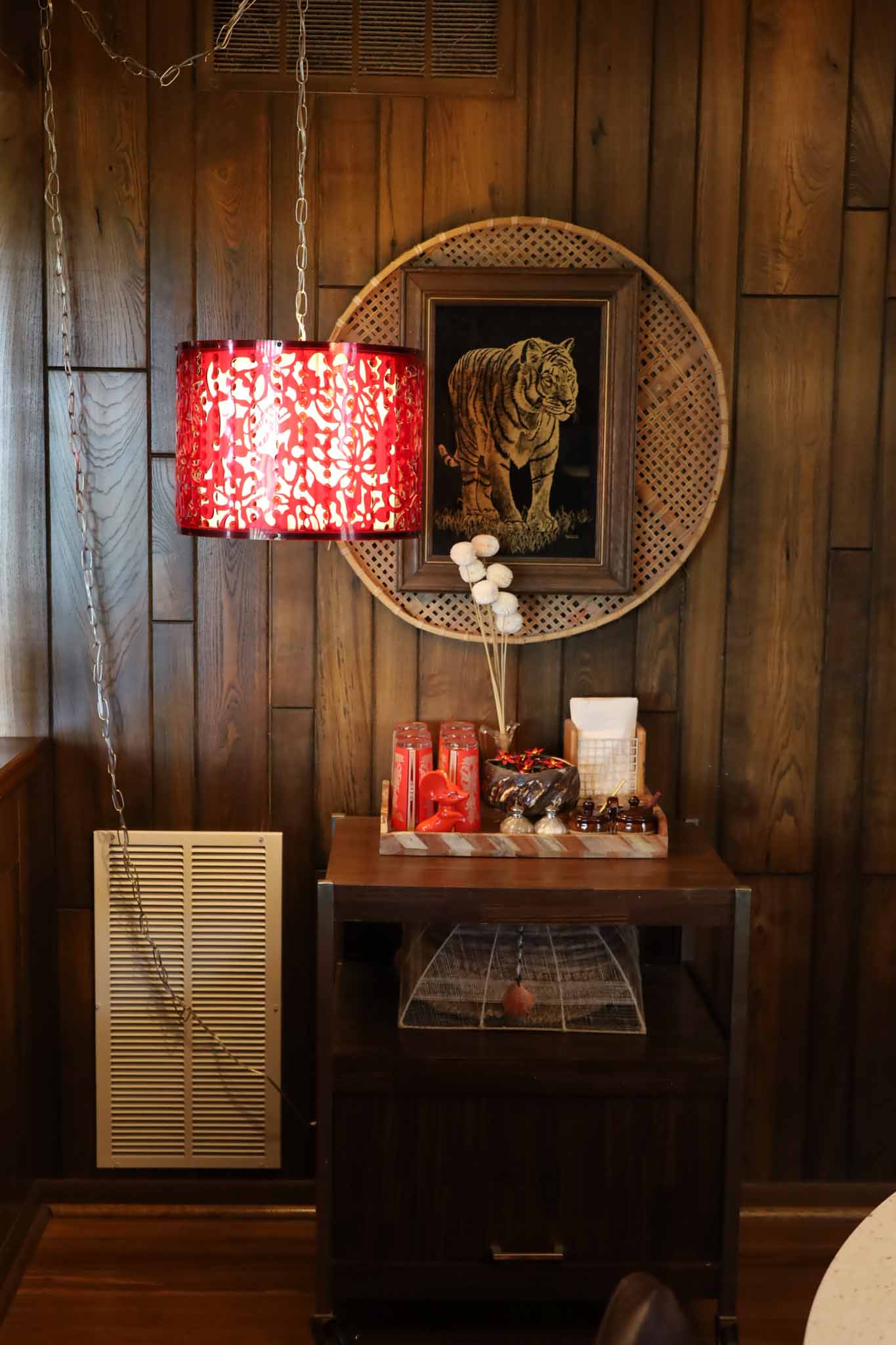 Bedside table with red lamp and wood paneling